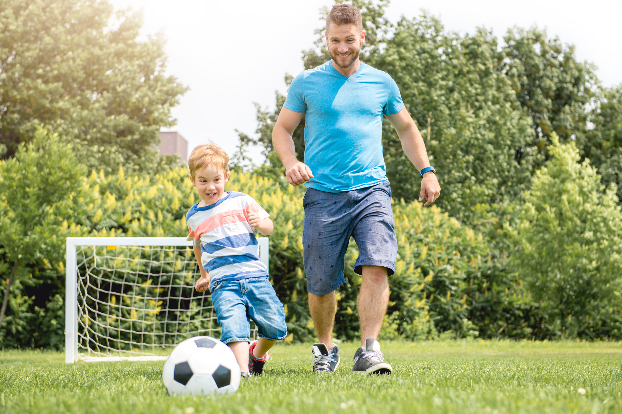 Vater spielt mit seinem kleinen Sohn Fussball