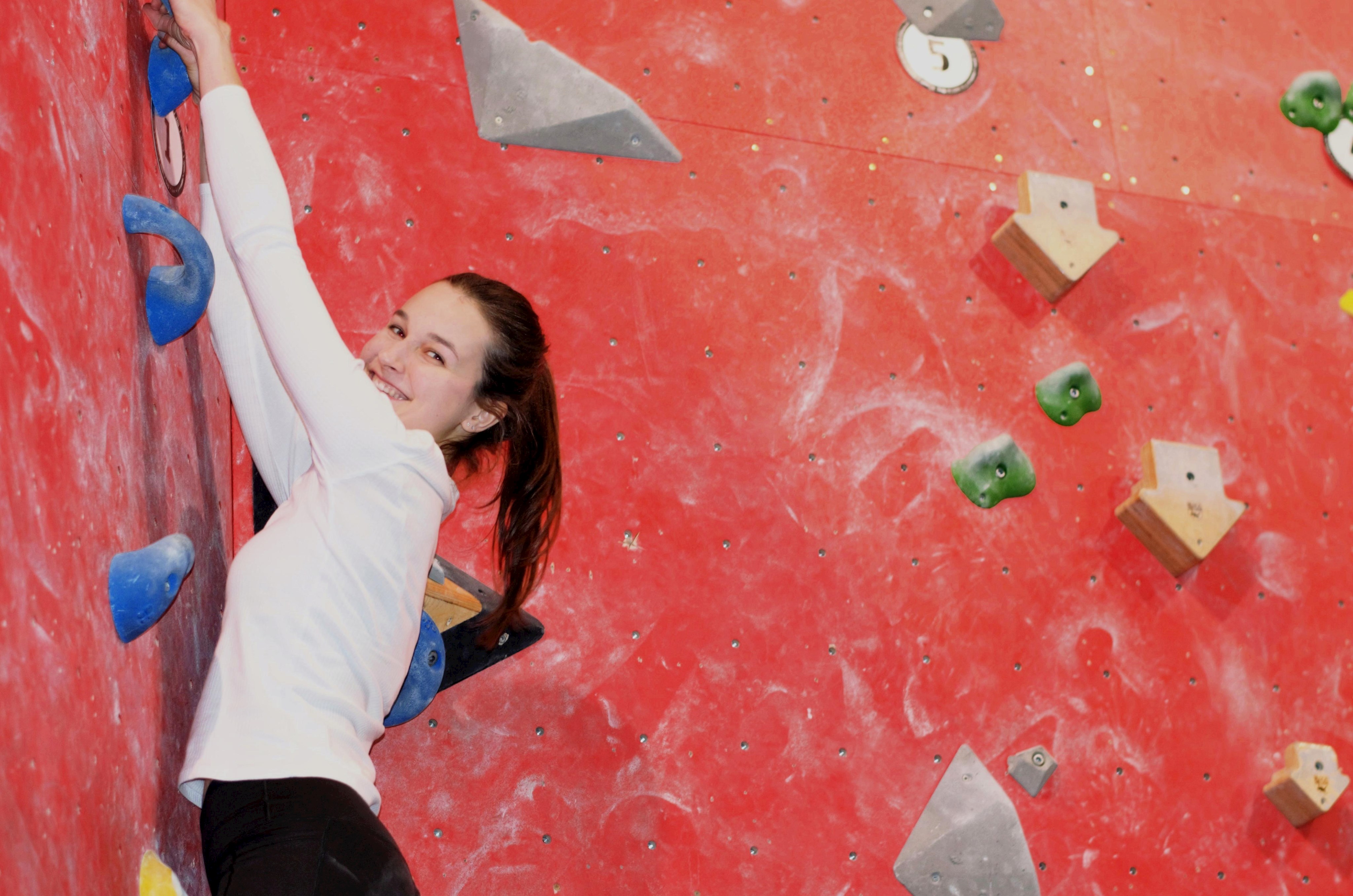 Mädchen an Boulderwand